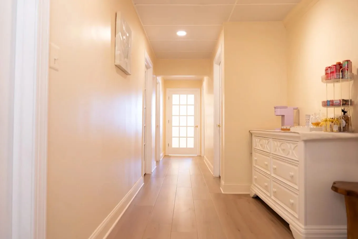 The quiet treatment-room hallway at Sweet & Smile Massage, warm wood doors and low amber lighting