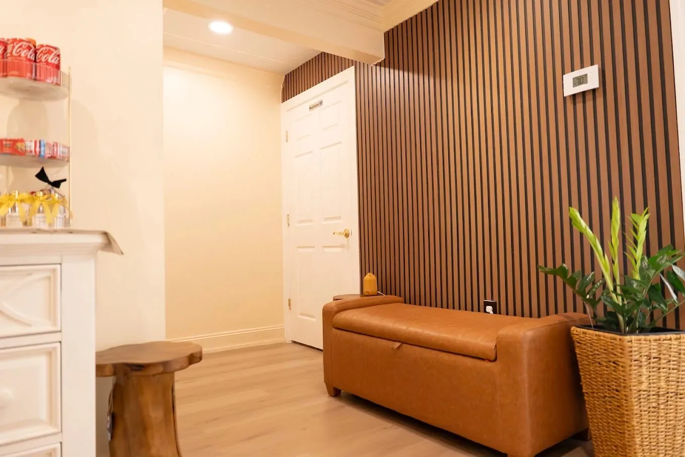 Lounge at Sweet & Smile Massage in Daly City, low seating and warm lamplight beside the treatment-room hallway