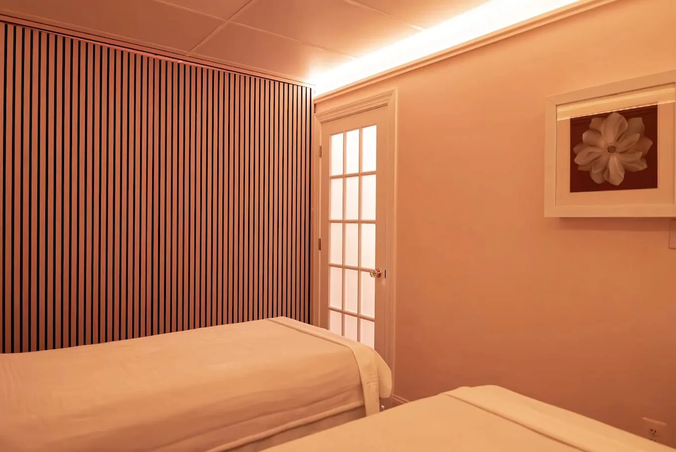 The couples room at Sweet & Smile Massage in Daly City, two extra-wide tables side by side under warm lamplight